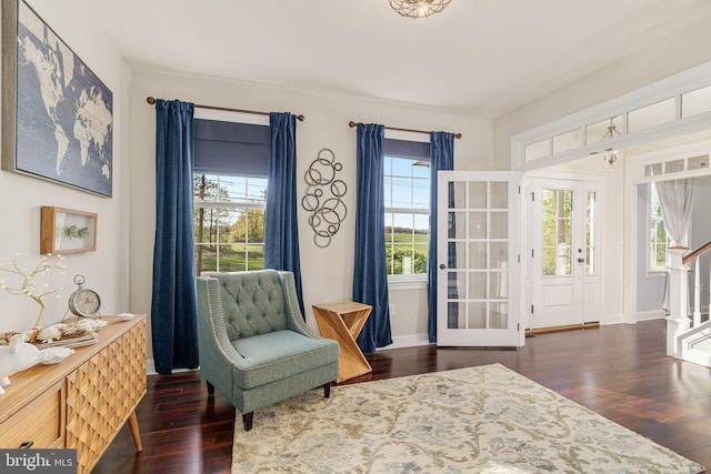 sitting room featuring baseboards, stairs, and dark wood-style floors