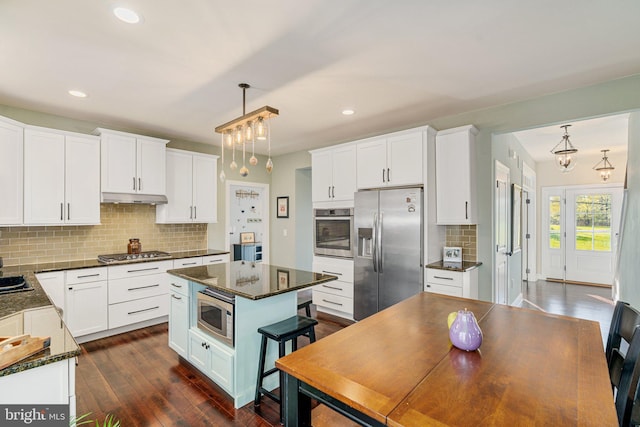 kitchen featuring backsplash, white cabinets, appliances with stainless steel finishes, and dark wood finished floors