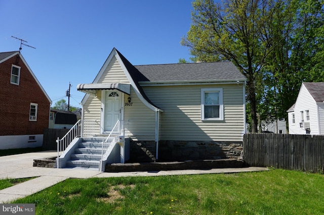 bungalow-style house with fence and a front lawn