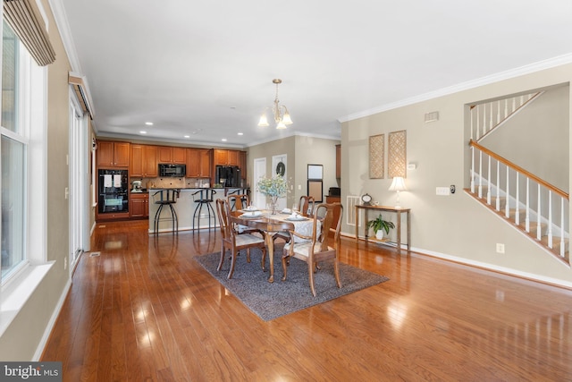 dining space featuring crown molding, a chandelier, dark wood finished floors, stairs, and baseboards