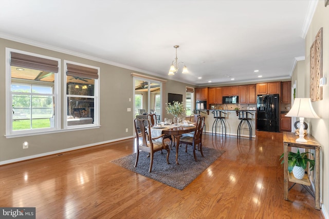 dining space with crown molding, baseboards, a chandelier, and a wealth of natural light