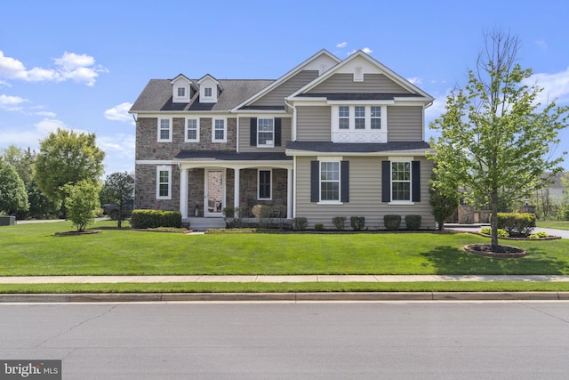 craftsman-style home featuring a front yard and stone siding