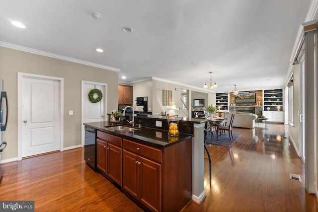kitchen with an inviting chandelier, a sink, a kitchen breakfast bar, black dishwasher, and open floor plan