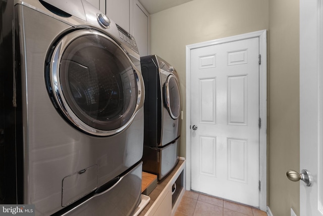laundry area featuring baseboards, cabinet space, independent washer and dryer, and light tile patterned floors