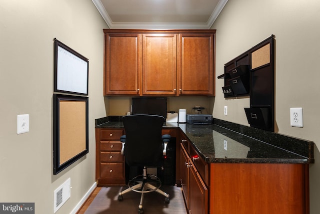 home office featuring visible vents, dark wood finished floors, built in desk, baseboards, and ornamental molding