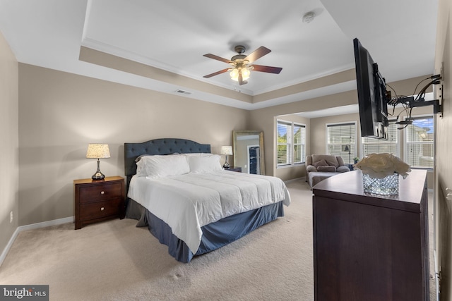 bedroom featuring visible vents, carpet floors, baseboards, a raised ceiling, and ornamental molding