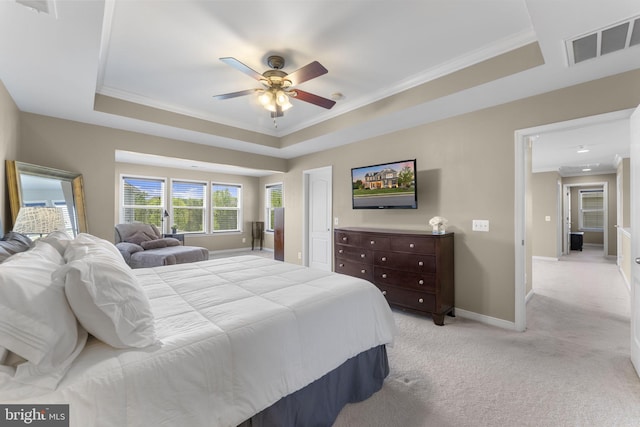 bedroom featuring crown molding, light carpet, baseboards, a tray ceiling, and visible vents