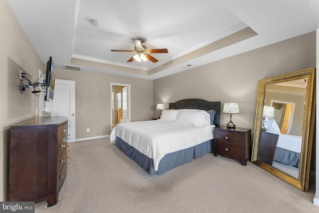 bedroom with visible vents, light carpet, ornamental molding, and a raised ceiling