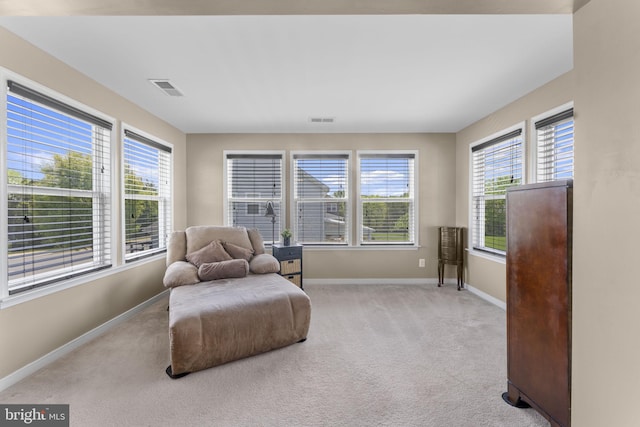 living area with carpet floors, baseboards, and visible vents