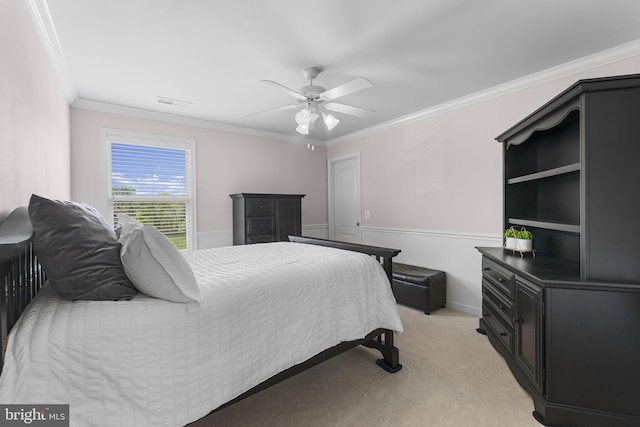 bedroom with visible vents, ornamental molding, ceiling fan, and light carpet