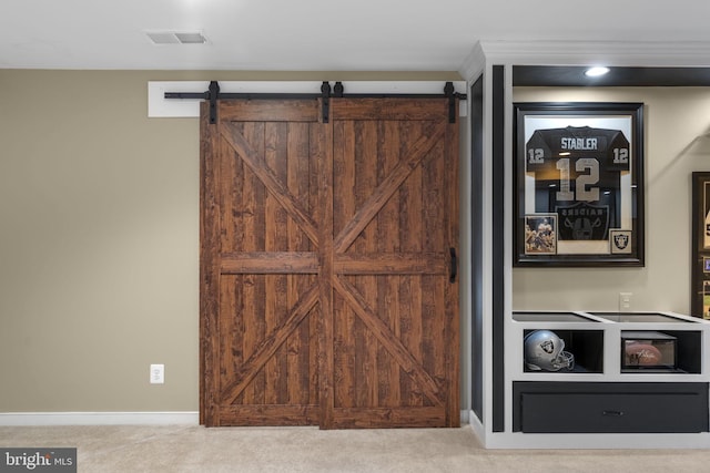 interior details featuring carpet floors, a barn door, baseboards, and visible vents