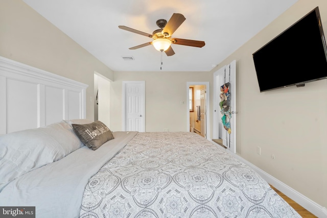 bedroom with a ceiling fan, baseboards, visible vents, and wood finished floors