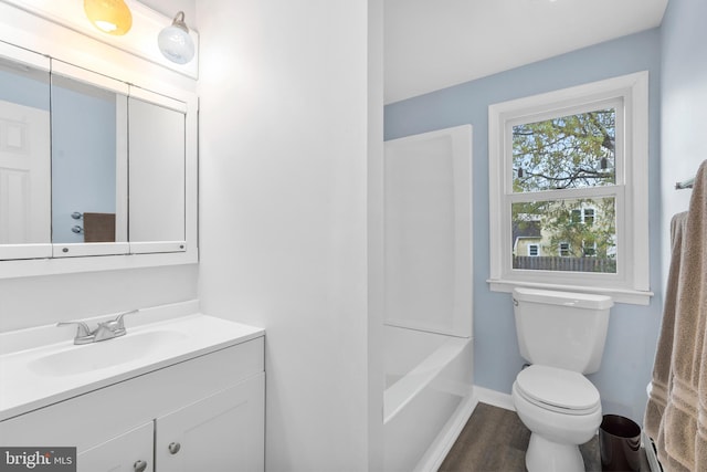 bathroom featuring vanity, baseboards, toilet, and wood finished floors