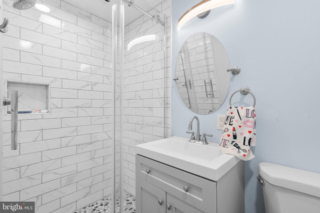 full bathroom featuring vanity, a stall shower, and toilet