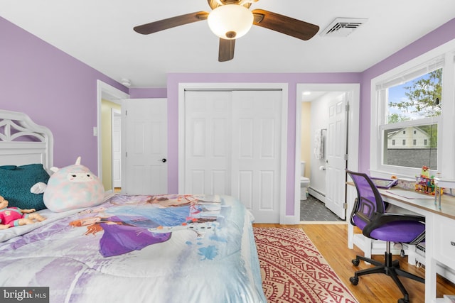 bedroom featuring visible vents, a closet, ceiling fan, light wood-type flooring, and a baseboard radiator