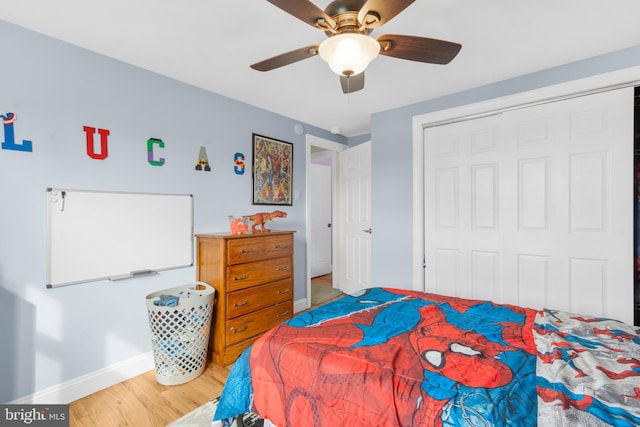 bedroom featuring a closet, baseboards, ceiling fan, and light wood-style floors