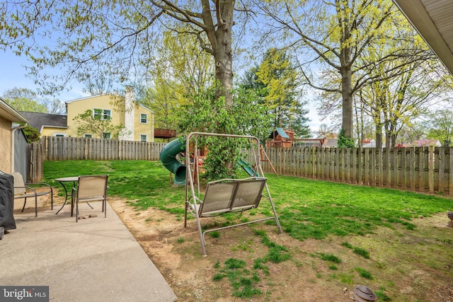 view of yard featuring a fenced backyard, a playground, and a patio area
