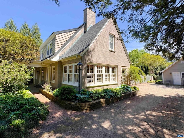 1012 Locust Ave, Charlottesville, VA 22901 - view of side of home with brick siding, roof with shingles, a chimney, and fence