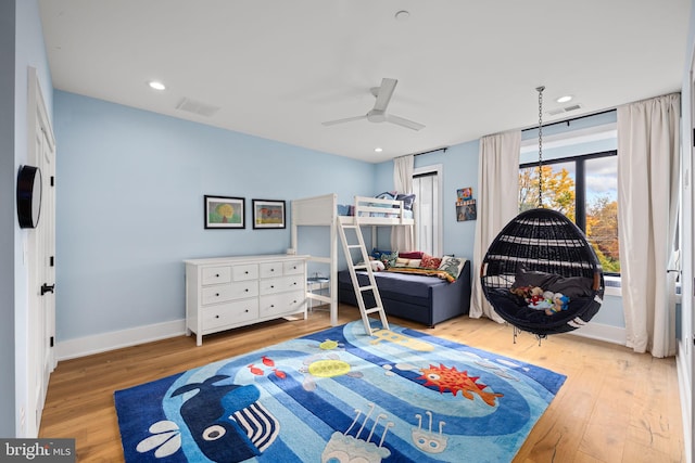 bedroom featuring visible vents, baseboards, wood finished floors, and ceiling fan