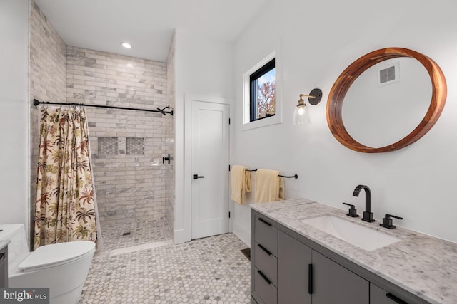 bathroom with toilet, a tile shower, visible vents, recessed lighting, and vanity