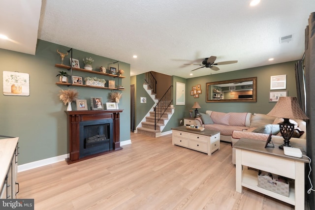 197 Crocus Ct, Quakertown, PA 18951 - living area with a ceiling fan, baseboards, a glass covered fireplace, light wood-style flooring, and stairs
