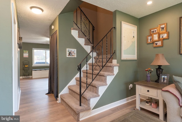 197 Crocus Ct, Quakertown, PA 18951 - stairs featuring wood finished floors, a textured ceiling, and baseboards