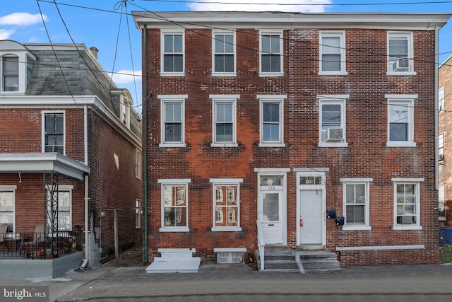 view of property featuring brick siding and cooling unit
