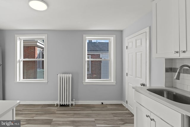 interior space with radiator, baseboards, and light wood finished floors