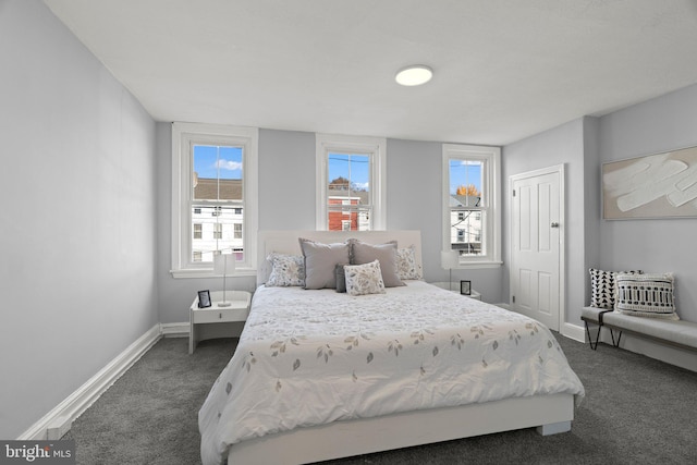 bedroom featuring dark carpet, a closet, and baseboards