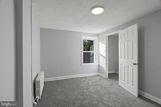 interior space with radiator heating unit, dark colored carpet, baseboards, and a textured ceiling