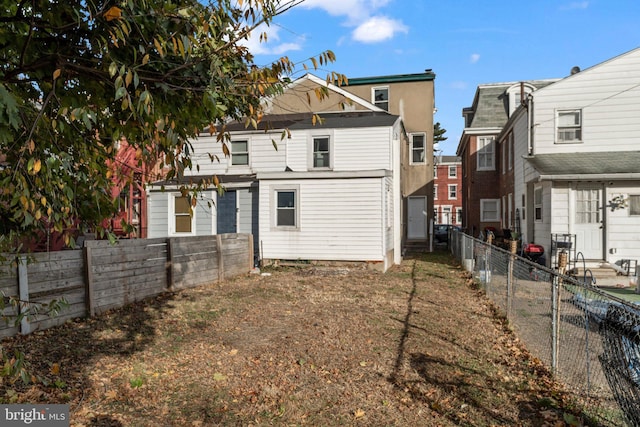 rear view of property featuring a fenced backyard
