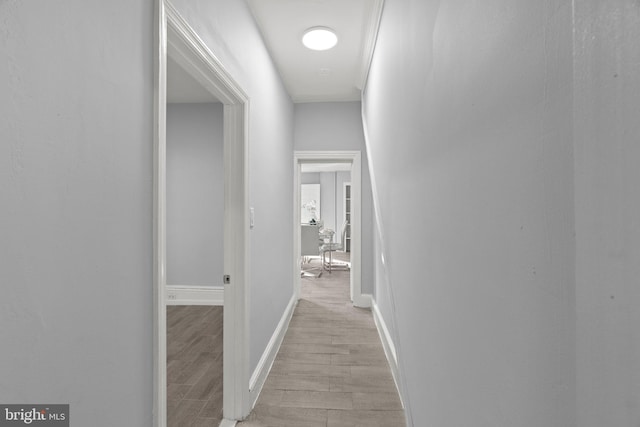 hall featuring baseboards and light wood-type flooring