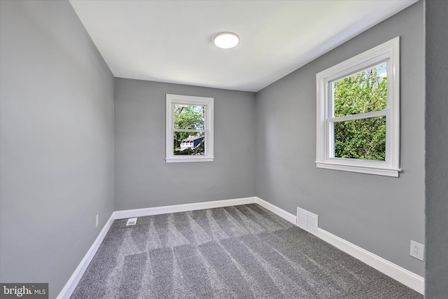 empty room with baseboards, carpet, and visible vents