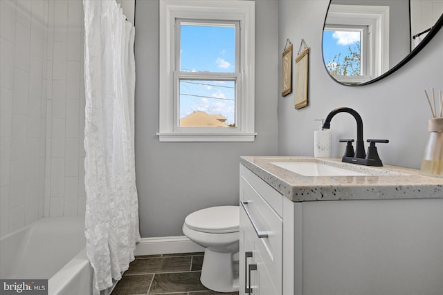 full bathroom with baseboards, shower / tub combo, toilet, and vanity