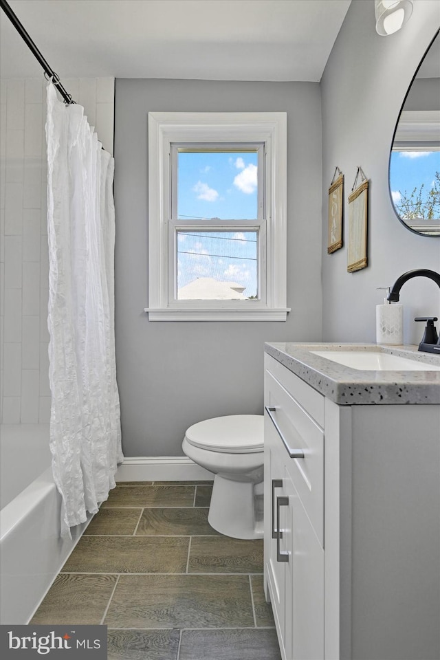 full bathroom with vanity, wood finish floors, toilet, and shower / tub combo