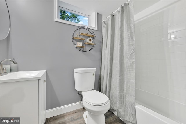 full bathroom featuring wood finished floors, vanity, baseboards, toilet, and shower / bath combo with shower curtain
