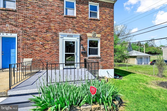 doorway to property featuring a lawn and brick siding