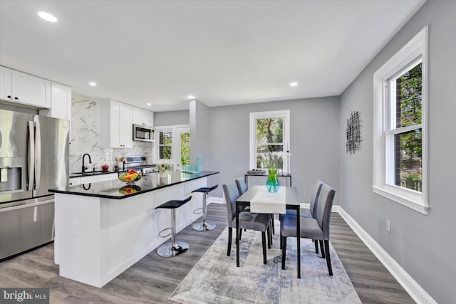 dining space with recessed lighting, baseboards, and dark wood-type flooring