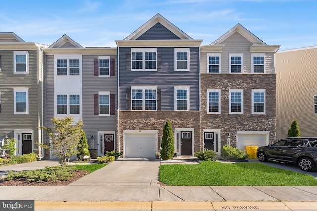 multi unit property featuring an attached garage, concrete driveway, and stone siding