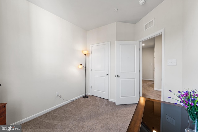 unfurnished bedroom with carpet floors, baseboards, and visible vents