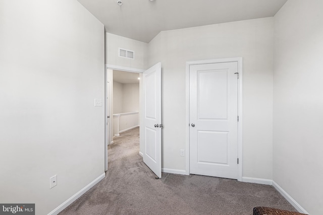 unfurnished bedroom featuring carpet floors, baseboards, and visible vents