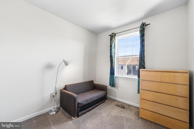 living area featuring visible vents, carpet, and baseboards