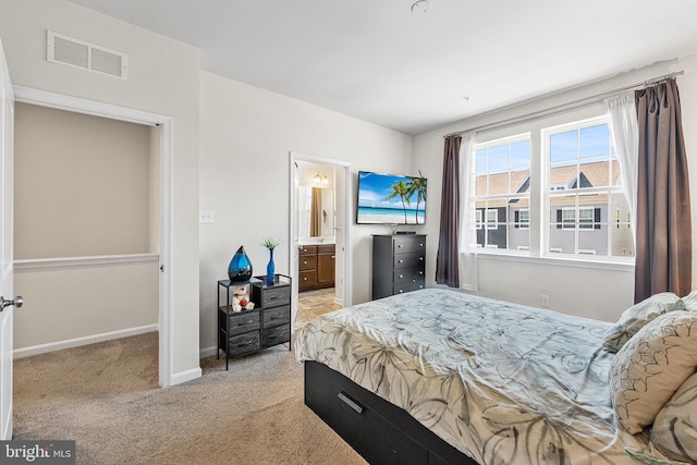 bedroom featuring visible vents, carpet, ensuite bath, and baseboards