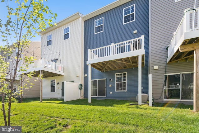 rear view of property with a lawn and central AC