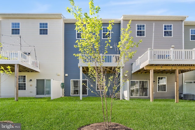 rear view of house with a lawn, central AC unit, and a deck