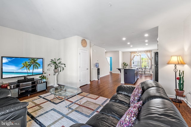 living room with recessed lighting, baseboards, an inviting chandelier, and dark wood-type flooring