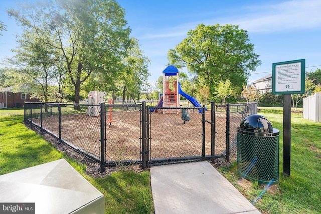 community playground featuring fence, a gate, and a yard