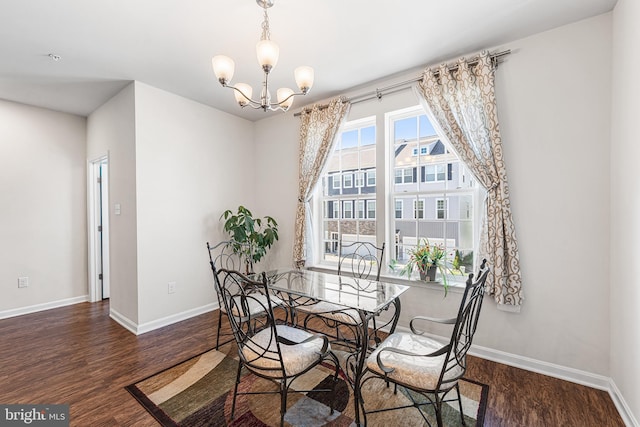 dining room featuring baseboards, a notable chandelier, and wood finished floors