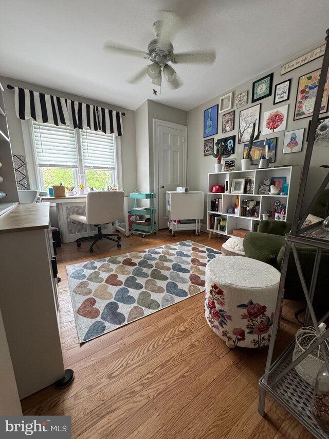 interior space with wood finished floors and a ceiling fan