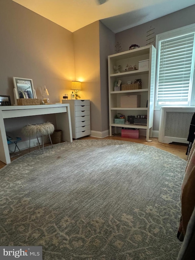 bedroom with baseboards and radiator